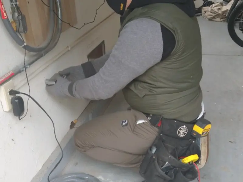 Electrician performing outlet wiring in a Canton garage